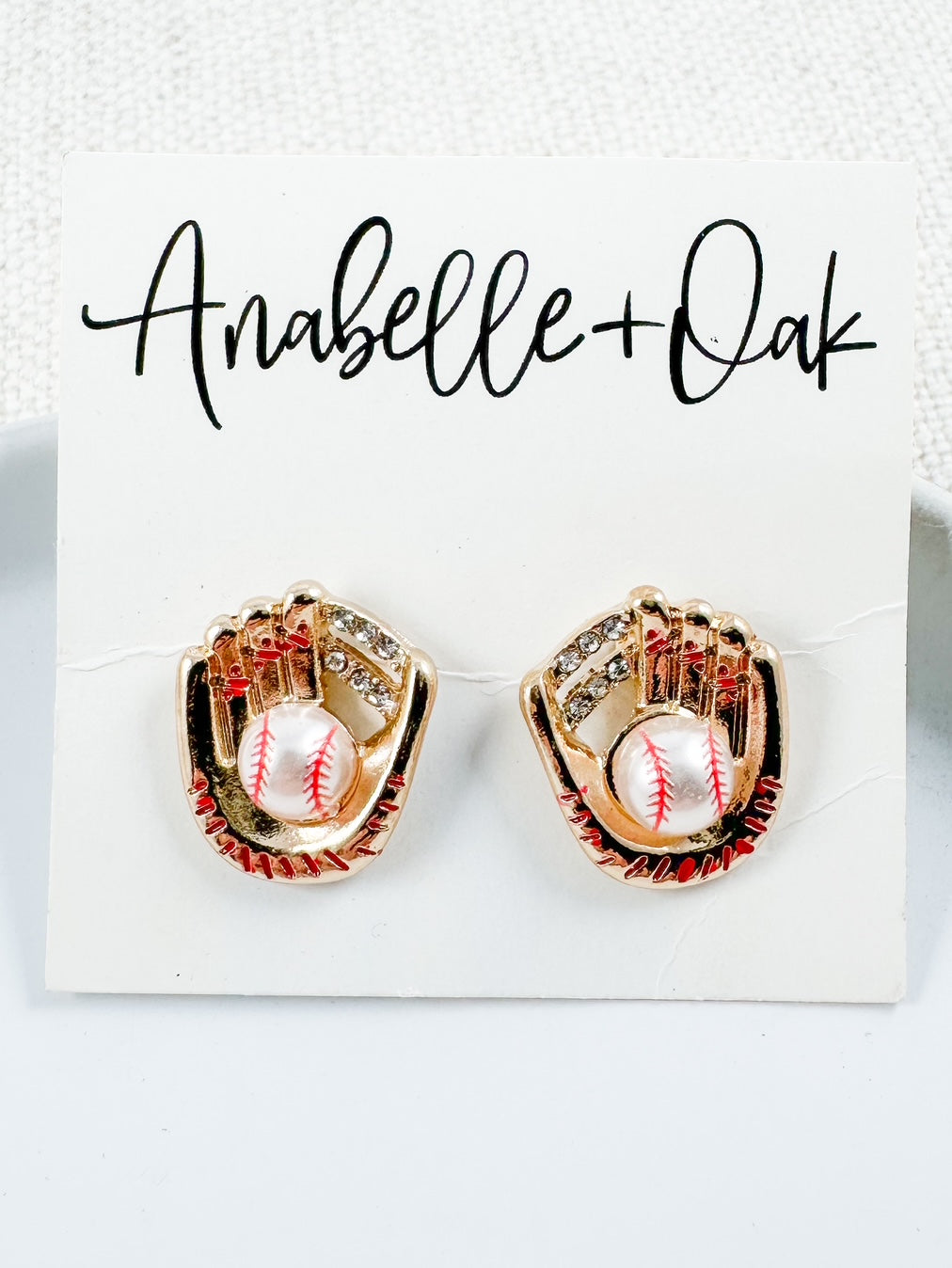 Golden baseball glove stud earrings with rhinestones and pearl baseballs shown on Anabelle+Oak jewelry card