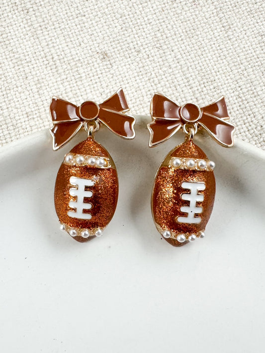 Glitter football earrings with brown enamel bows and pearl accents