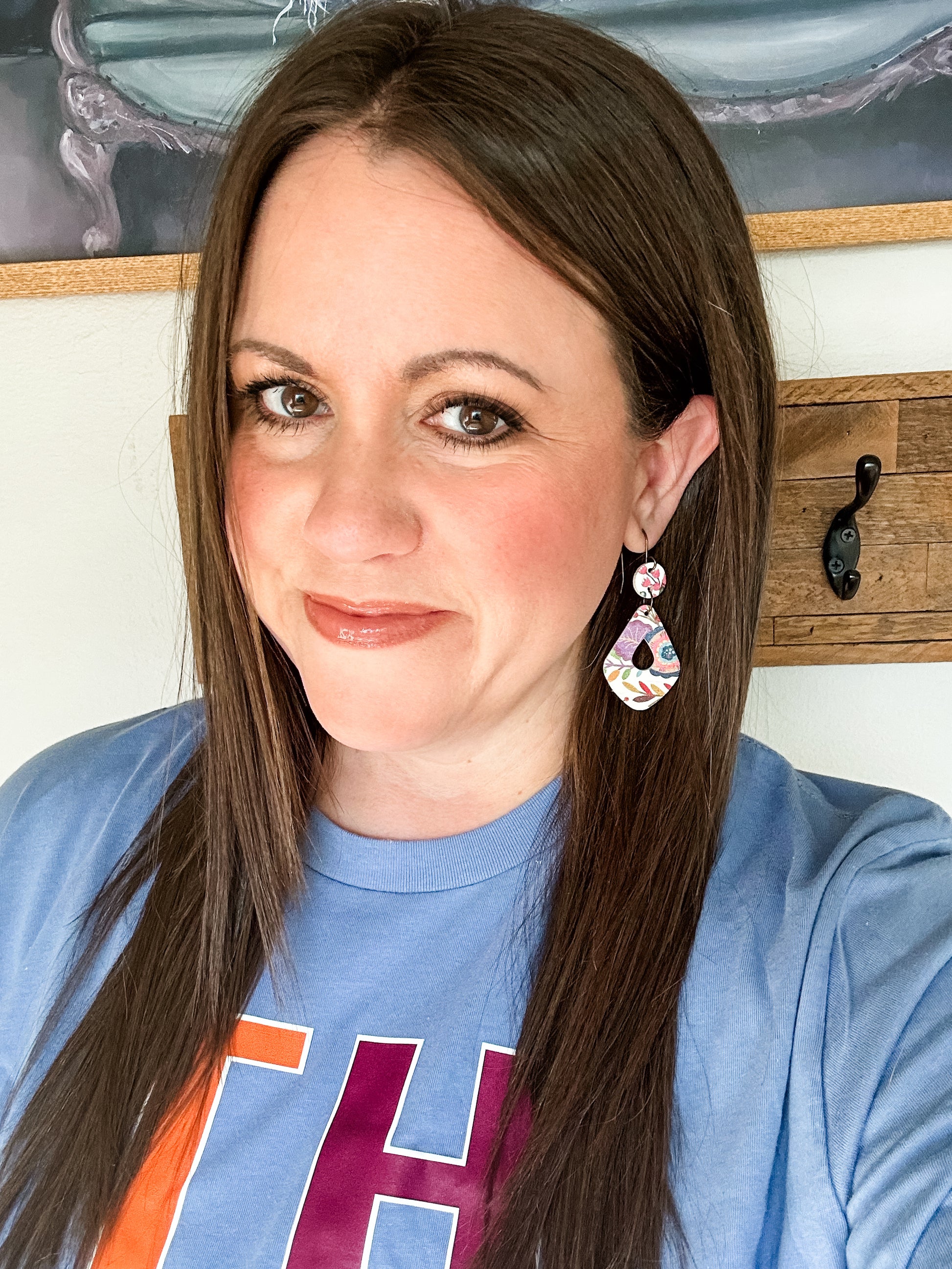 Woman wearing colorful floral teardrop earrings made from genuine cork and leather, paired with a blue “THANKFUL” long-sleeve tee. The image highlights the lightweight fall-inspired design.