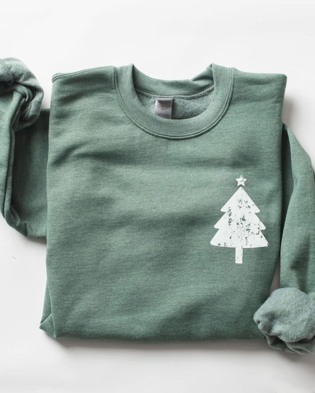 Evergreen Season Sweatshirt folded flat in heather forest green with white distressed Christmas tree graphic, cozy unisex holiday crewneck sweatshirt