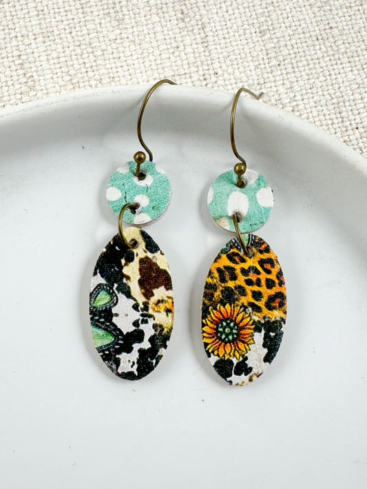 Wildflower Rodeo Earrings — handmade leather and cork dangle earrings featuring turquoise polka dots, leopard print, cowhide, and sunflower design, 1.5-inch drop.