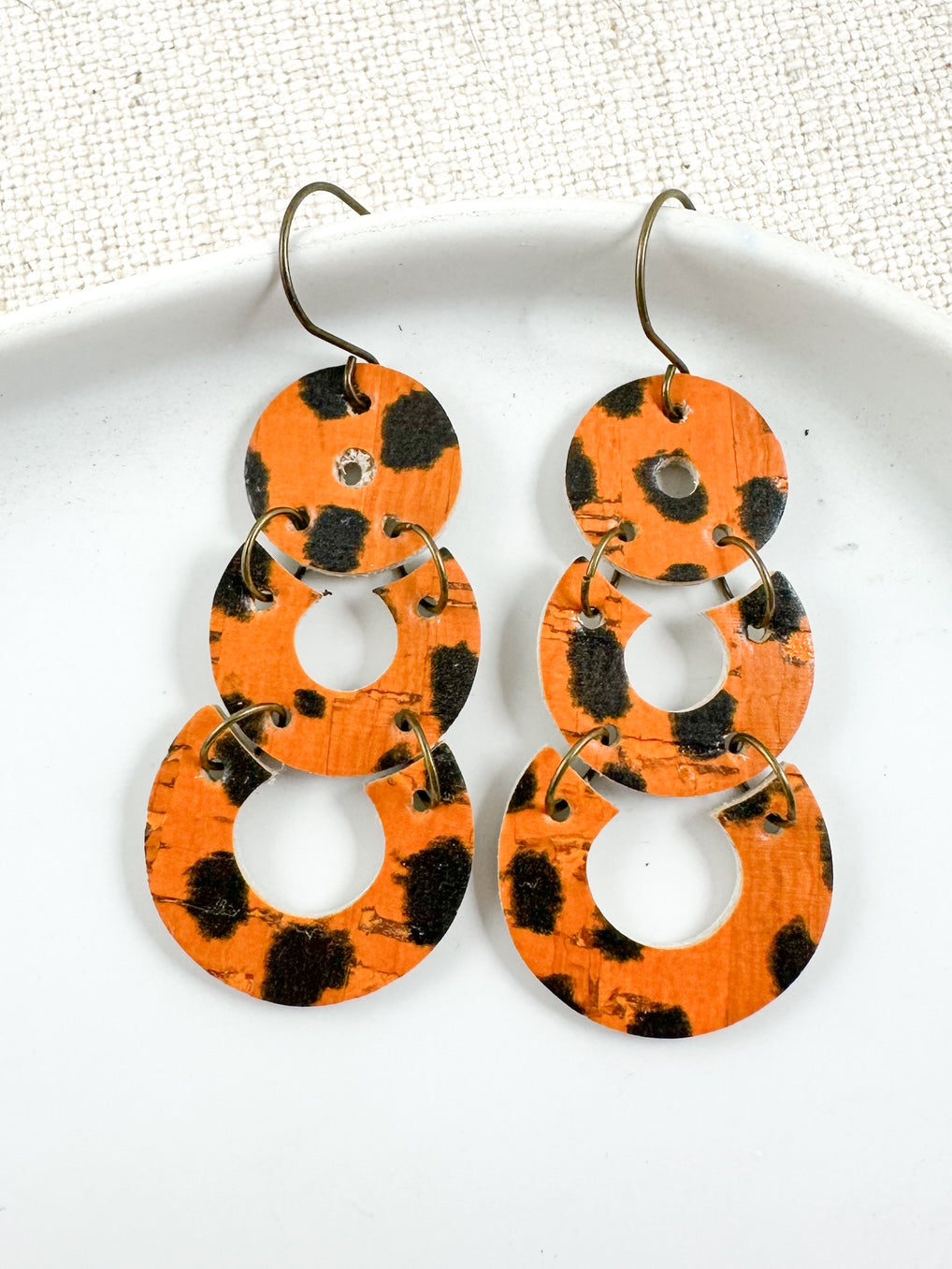 Handmade 2-inch burnt orange animal print leather and cork earrings with black cheetah spots