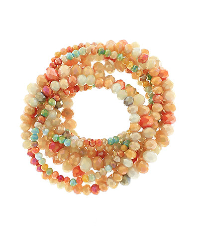 Coral and mint beaded bracelet set of nine with faceted glass beads in layered stack, displayed in coiled arrangement on white background