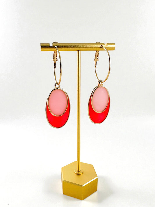 Gold hoop earrings with removable geometric drops displayed on gold jewelry stand
