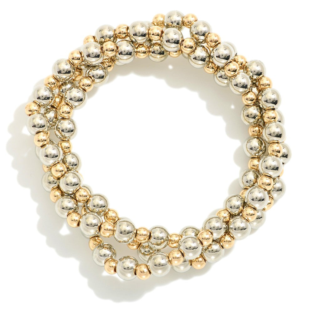 Set of three mixed metal stretch bracelets featuring large silver beads and smaller gold spacer beads displayed stacked together.