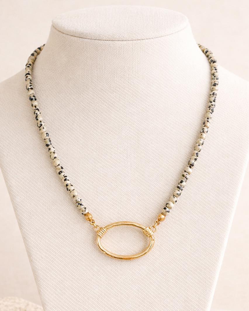Necklace with gold oval pendant on a mannequin against a white background