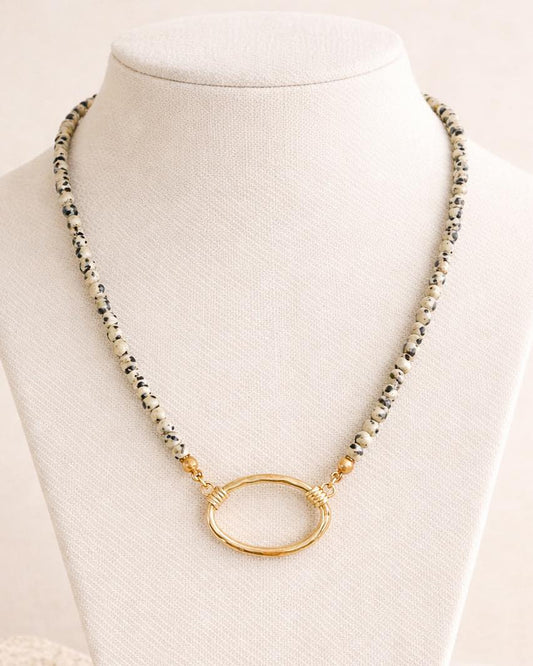 Necklace with gold oval pendant on a mannequin against a white background