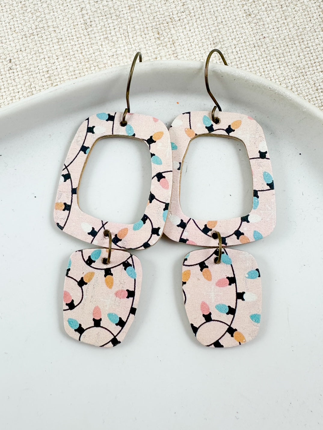 Blush cork geometric earrings with colorful Christmas light pattern