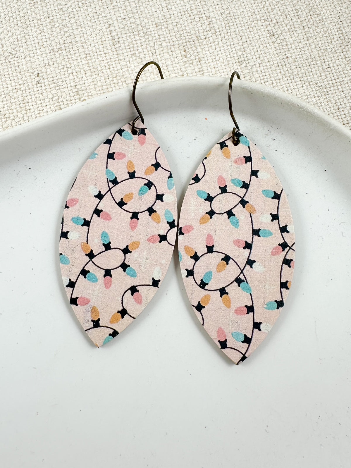 Blush pink cork earrings with pastel string light pattern in leaf shape