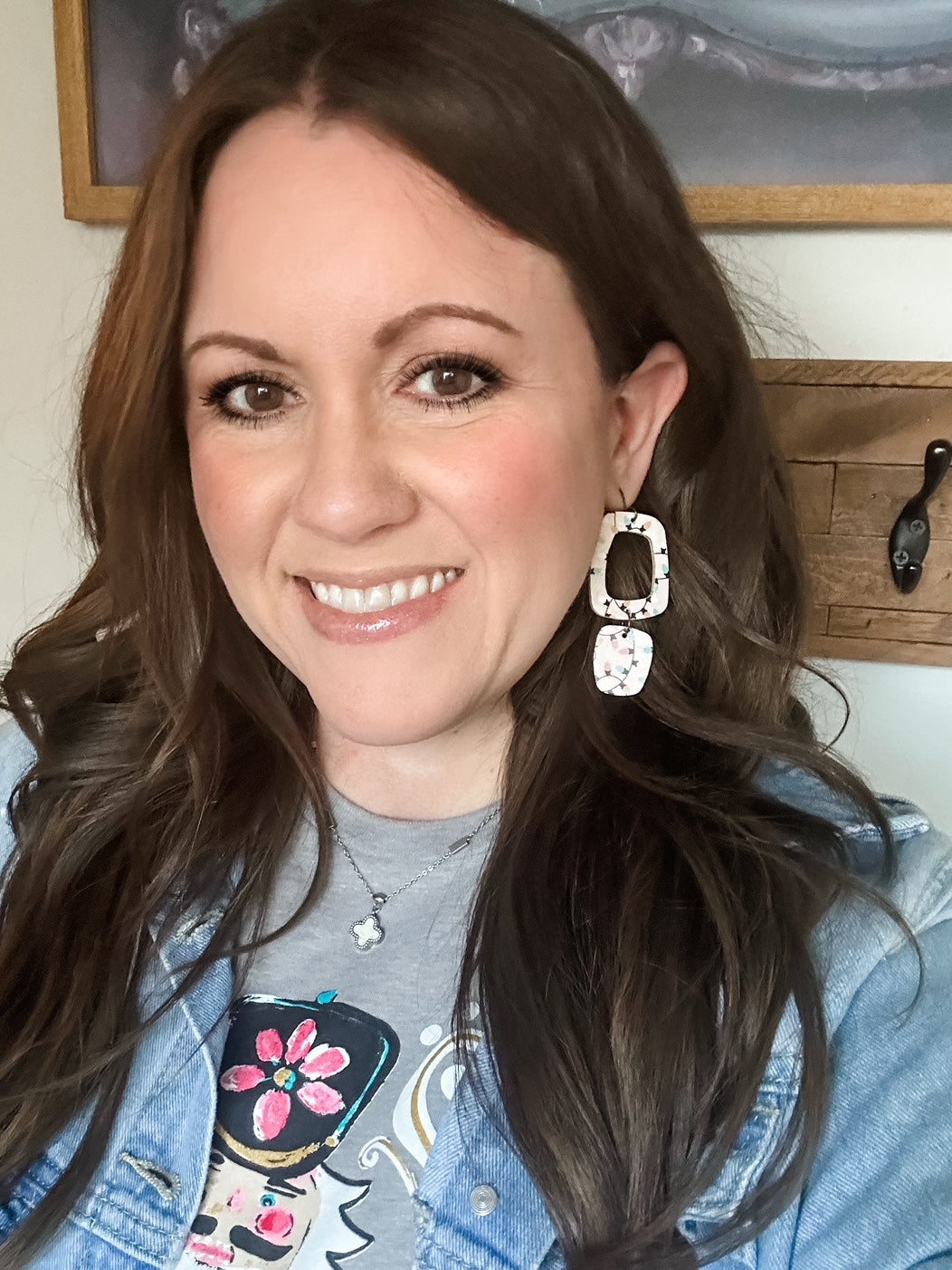 Woman wearing geometric earrings made from blush cork with colorful Christmas lights design