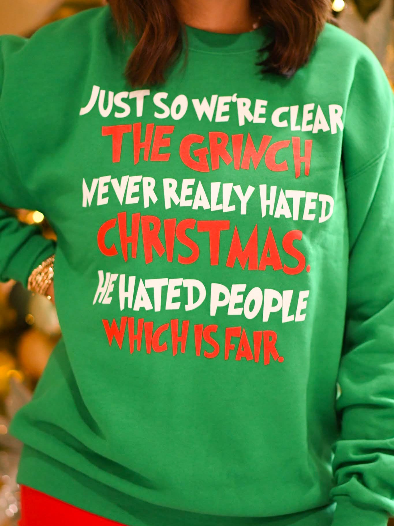 Green sweatshirt with bold red and white holiday text that reads “Just so we're clear the Grinch never really hated Christmas. He hated people which is fair.”