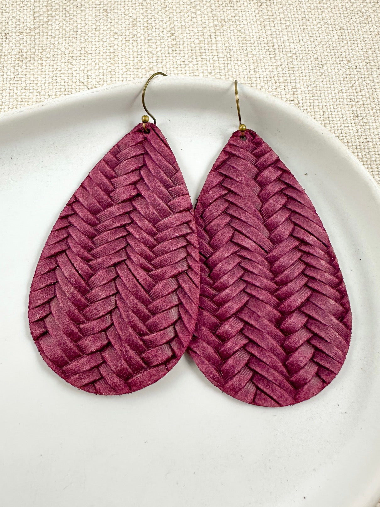 Handmade mulberry leather teardrop earrings with a woven textured pattern on a light background.