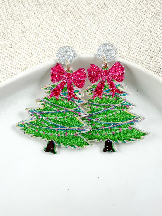 Acrylic evergreen-shaped drop earrings with ribbon detail on a light background