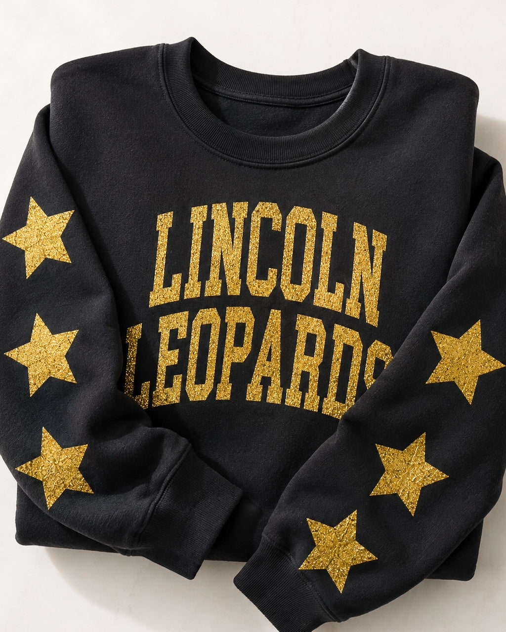 Black All-Star Leopard Sweatshirt folded to show the gold-glitter Lincoln Leopards lettering and sleeve stars