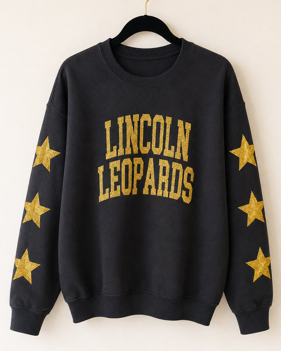 Black Gildan crewneck sweatshirt with gold-glitter Lincoln Leopards lettering and stars down both sleeves