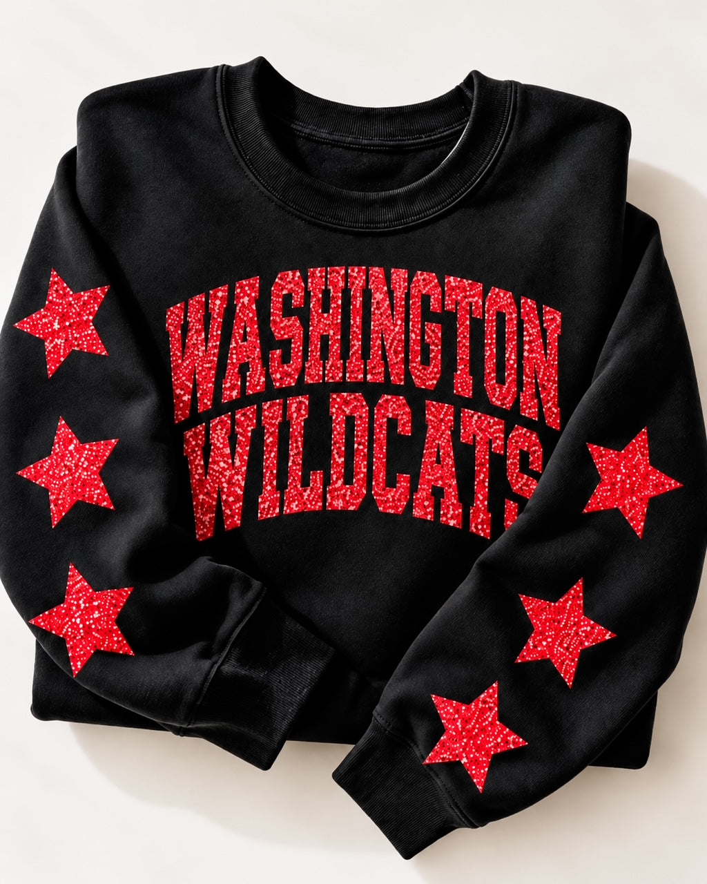 Folded black Washington Wildcats sweatshirt featuring bold red glitter lettering and a soft fleece crewneck design.