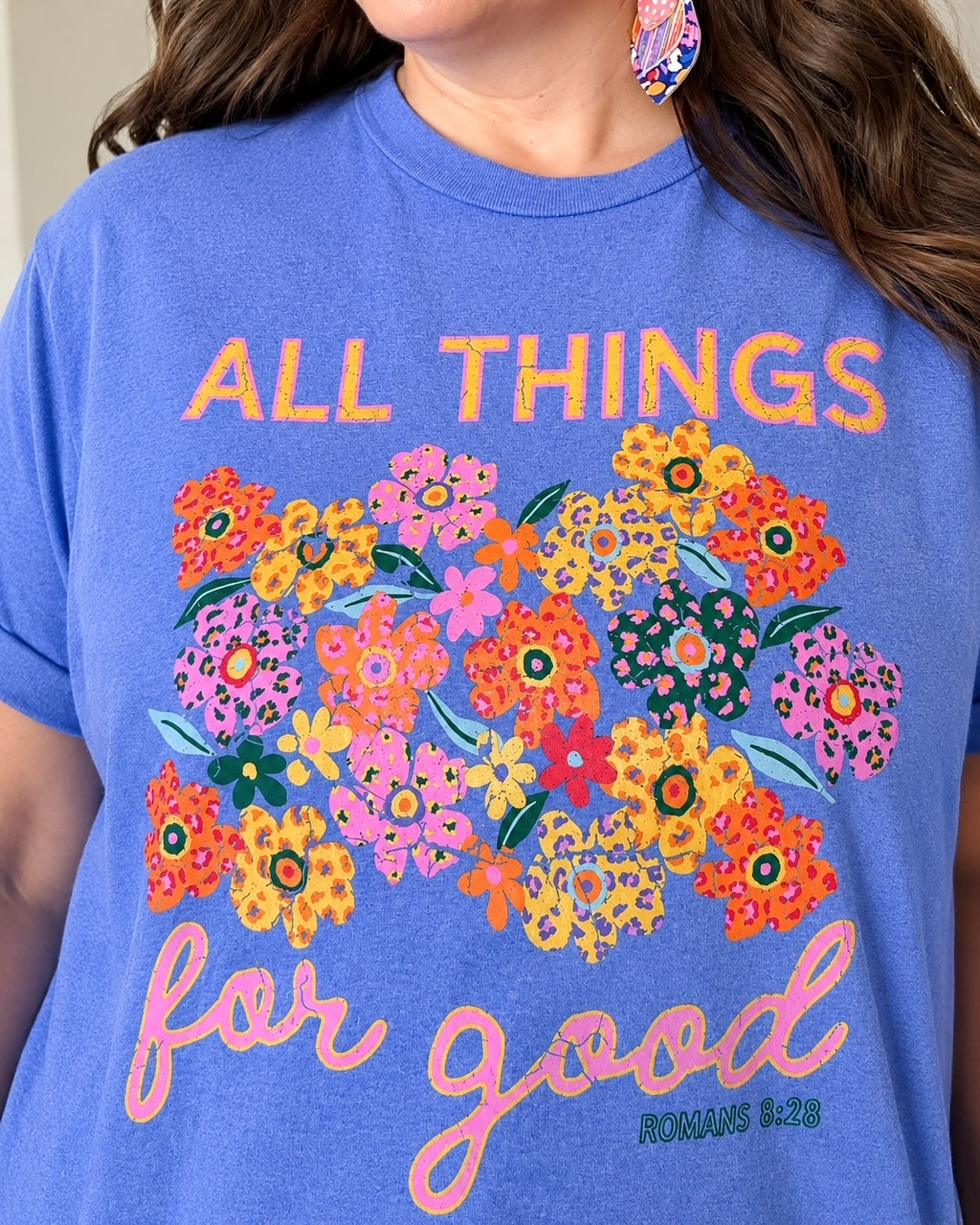 Close-up of woman wearing colorful All Things for Good Romans 8:28 graphic tee
