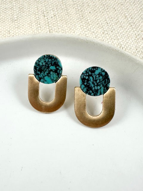  Turquoise stud earrings with round faux turquoise stones and gold-toned arch-shaped metal drops on a white surface.
