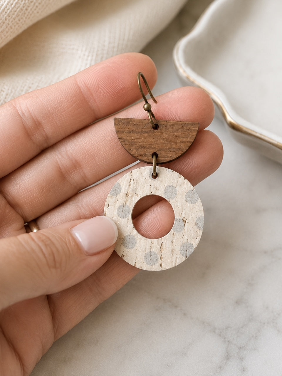 Aspen Mist 2.5-inch handmade cork and walnut wood earrings shown in hand for size.