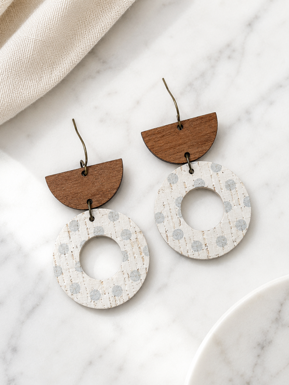 Aspen Mist handmade neutral cork and walnut wood geometric dangle earrings on white marble.
