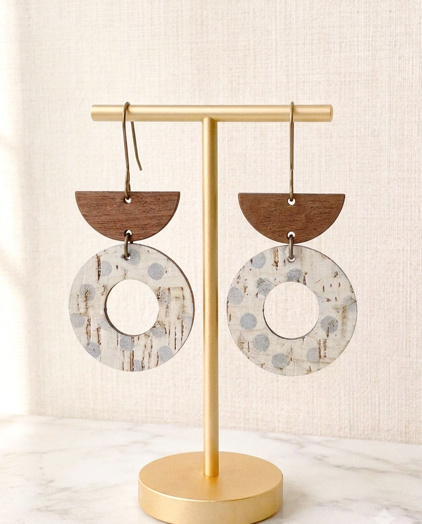 Aspen Mist lightweight geometric cork and walnut wood earrings displayed on a matte gold stand.