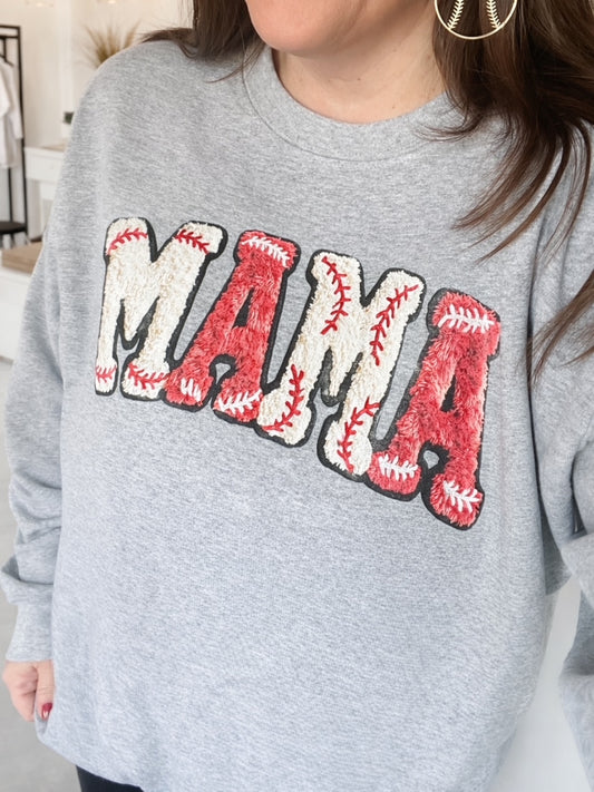 Woman wearing heather gray shirt with large red MAMA graphic with baseball stitch detailing.