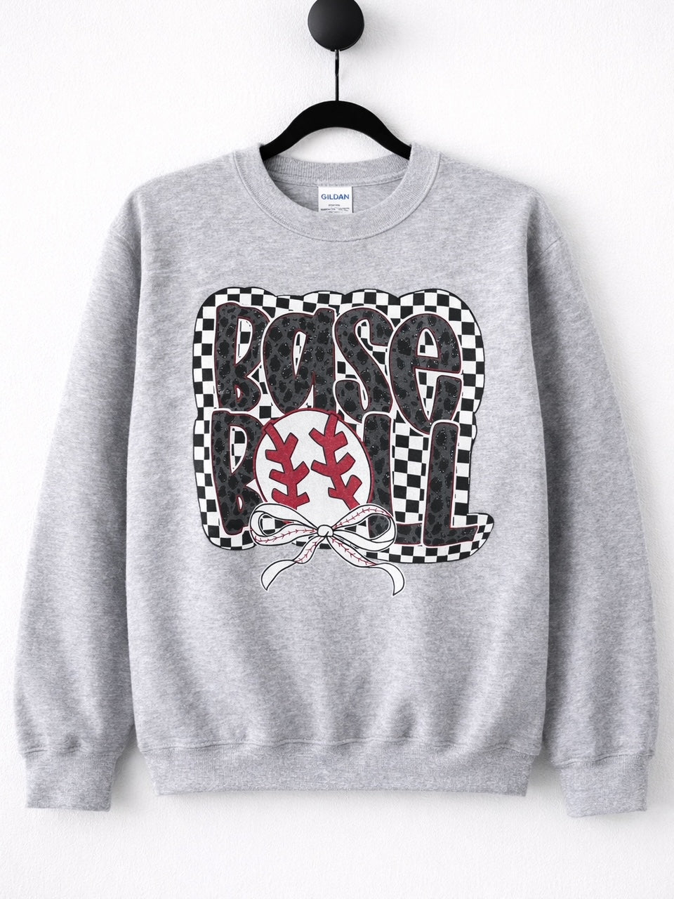 Heather gray crewneck sweatshirt hanging on black hanger with large checkerboard, leopard print, and baseball bow graphic that reads Baseball.