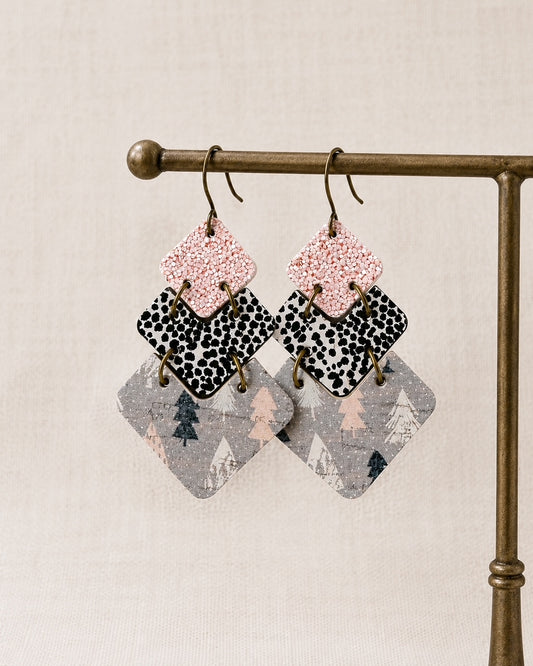 Blush Frost handmade cork and genuine leather winter statement earrings on a gold jewelry stand