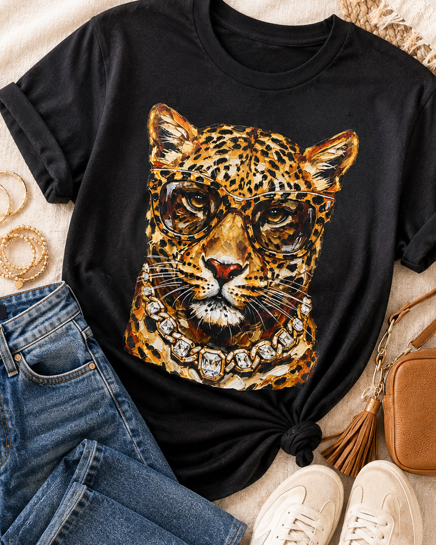 Black Bougie Leopard tee styled with jeans, cream sneakers, gold bracelets, and a camel crossbody bag