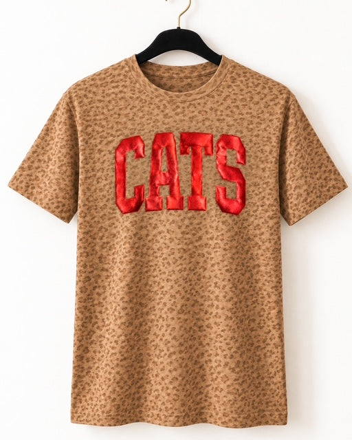Tonal leopard-print Cats in the Wild Tee displayed on a black velvet hanger with a matte gold hook.