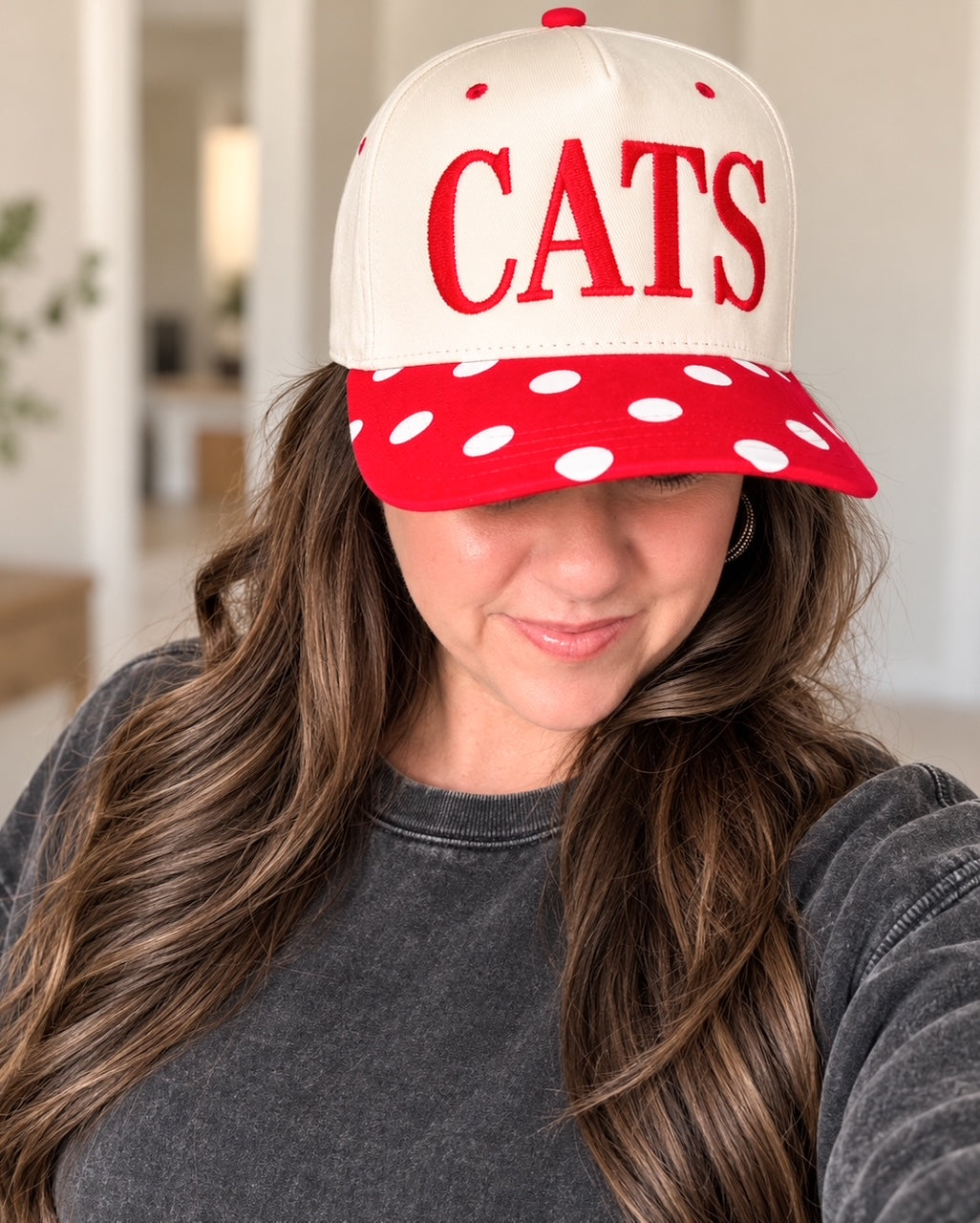 Brunette model wearing the cream CATS Pep Rally Hat with a faded charcoal sweatshirt.