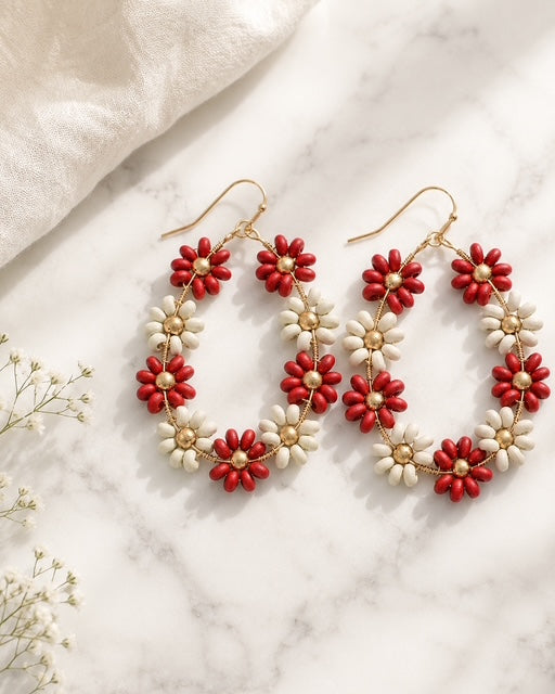 Daisy Lane Earrings in red and ivory floral wood beads with gold-tone surgical stainless steel ear wires on a white marble background.