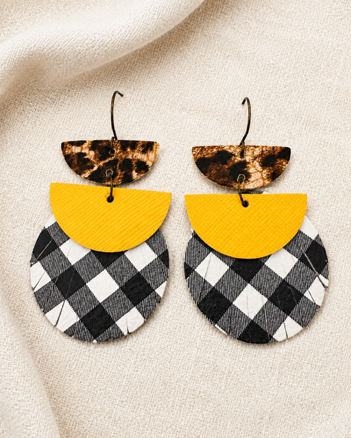 Dress Code Earrings arranged on softly draped ivory fabric.