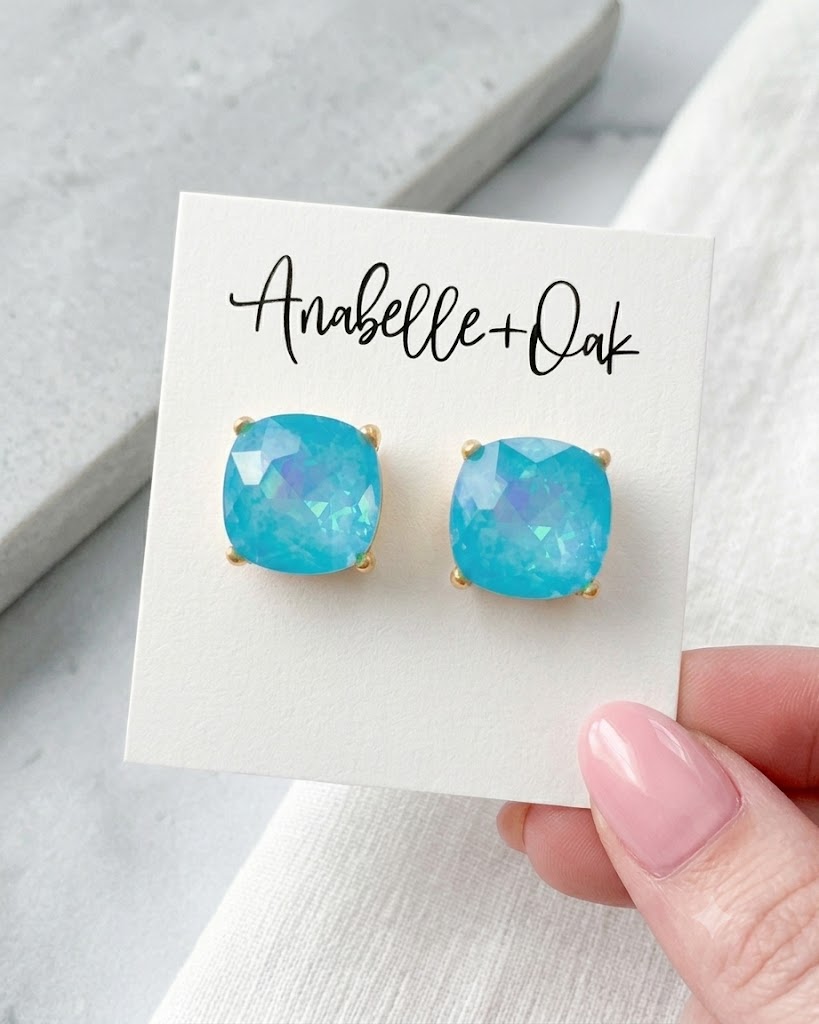 Turquoise 5/8-inch square stud earrings with iridescent shimmer displayed on an Anabelle+Oak jewelry card.