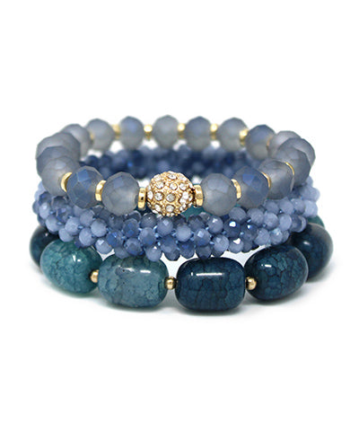 Set of three blue beaded stretch bracelets displayed together with mixed textures and gold accents