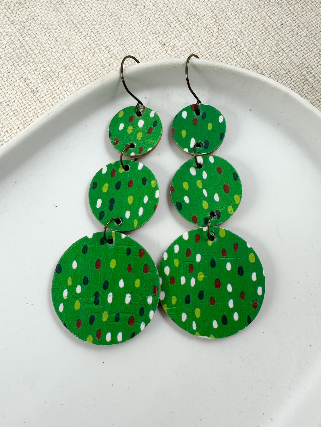 Evergreen Confetti Cork circle dangle earrings with layered circle shapes on white plate