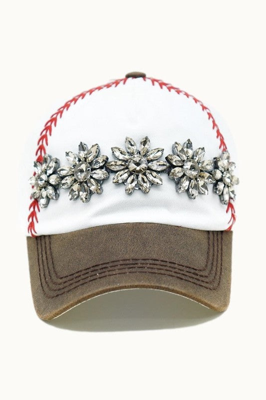 Front view of white baseball cap with red embroidered stitching, distressed brown bill, and topaz stone embellishment.