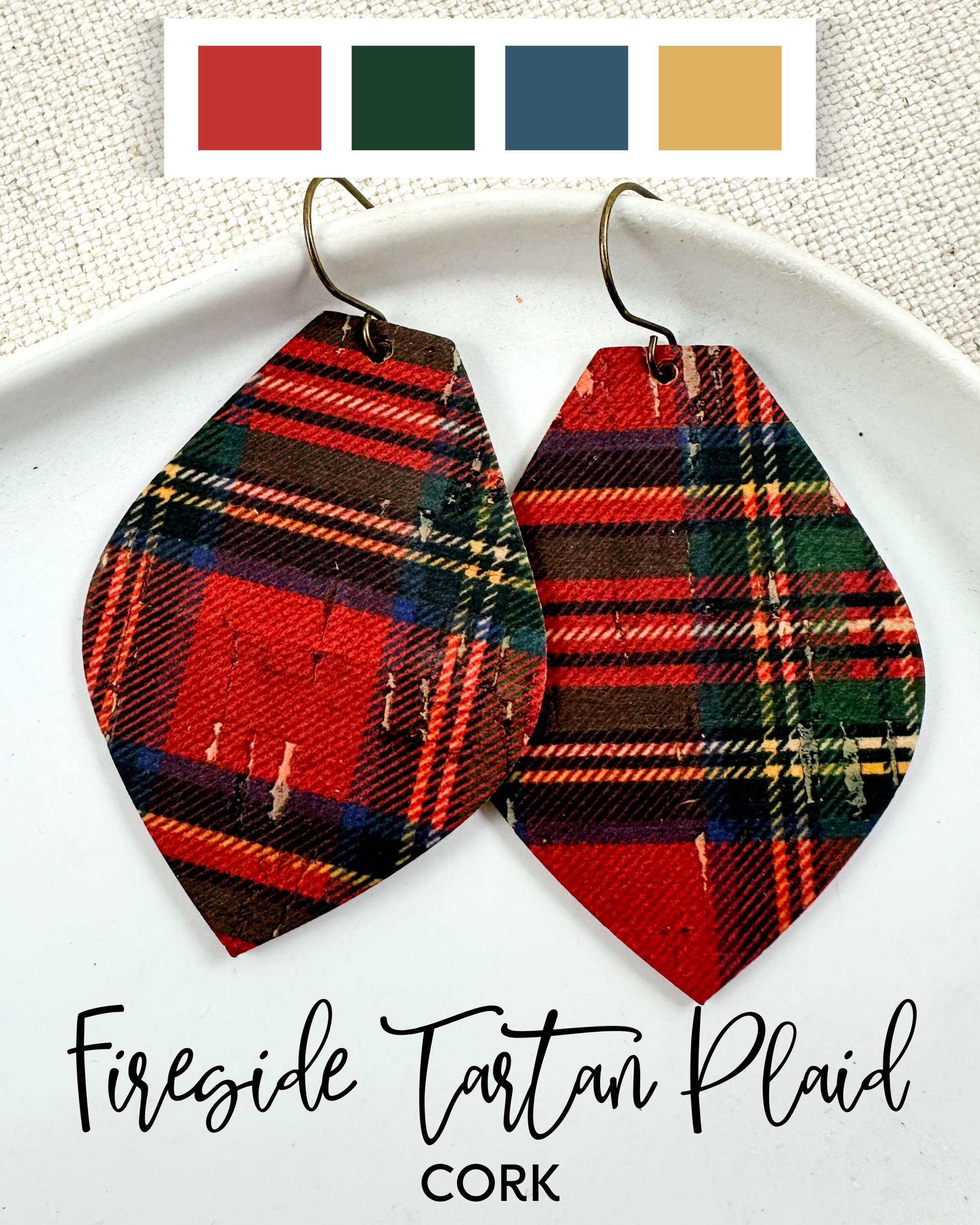 Fireside Tartan Plaid cork earrings in red, green, and navy plaid, shown as large statement drop earrings on a white plate.