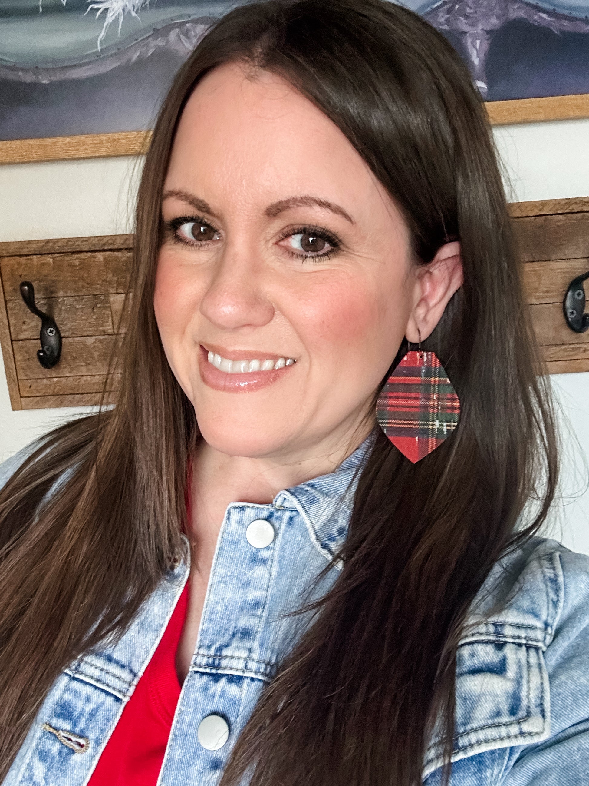 Woman wearing red tartan plaid cork earrings with a denim jacket.