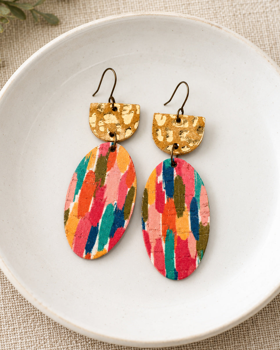 Handmade Gilded Brushstroke earrings with colorful abstract brushstroke patterns and gold leopard print accents styled in a white ceramic dish on neutral linen.