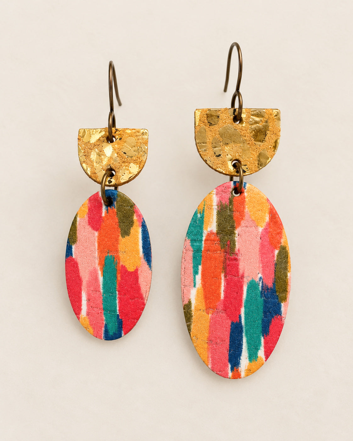 Gilded Brushstroke Earrings shown side by side in small and large sizes, featuring colorful oval leather drops and metallic gold leopard tops.