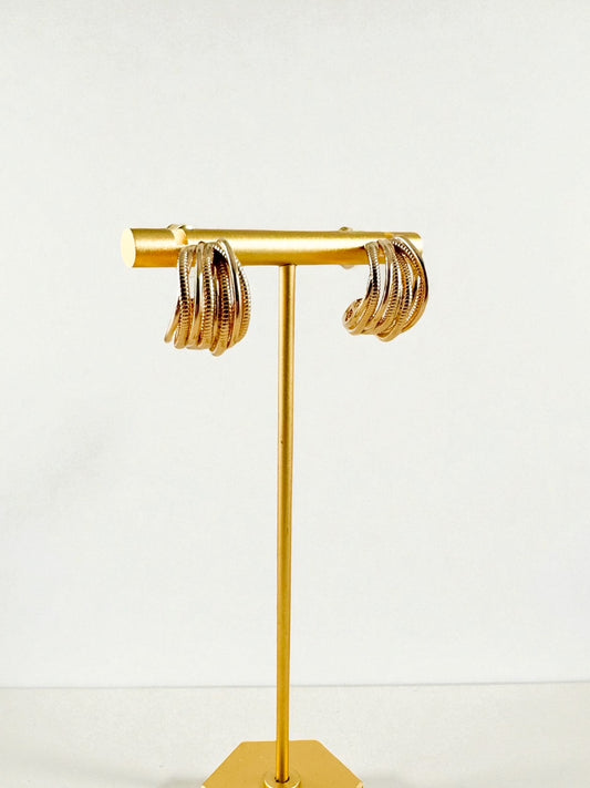 small worn gold multi-band wrap hoops displayed on a gold earring stand