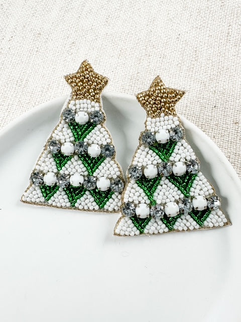 Green beaded Christmas tree statement earrings displayed on a white ceramic dish
