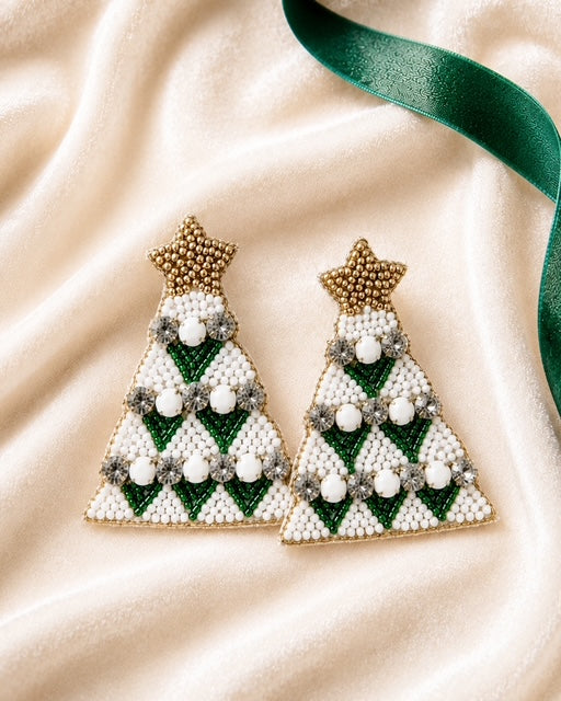 Green Christmas tree statement earrings styled on ivory satin with a green velvet ribbon