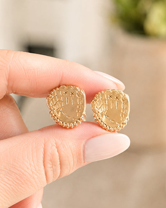 Gold baseball glove stud earrings shown between fingers to demonstrate their 3/4-inch size.