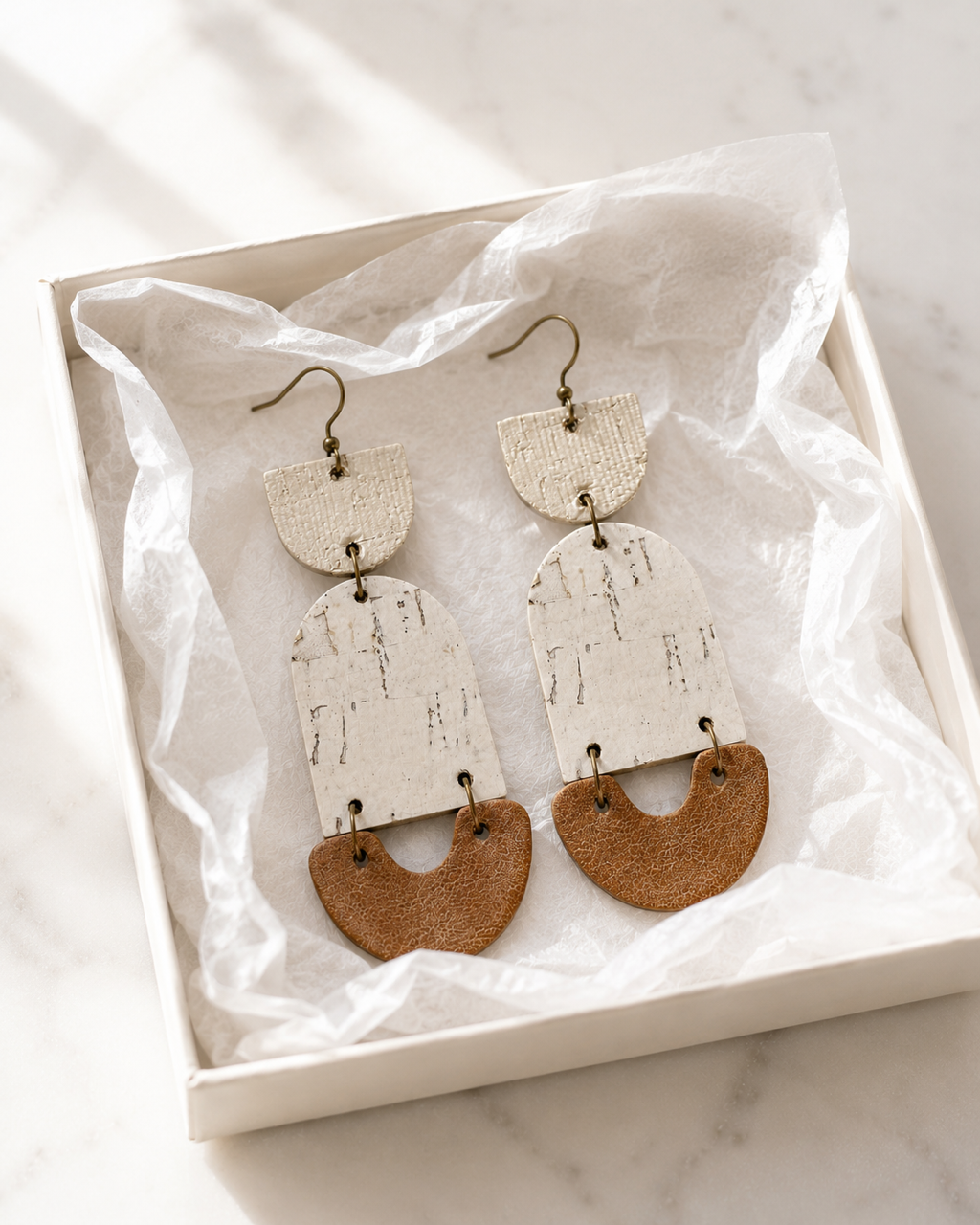 Golden Birch handmade cork and leather earrings packaged in a white gift box.