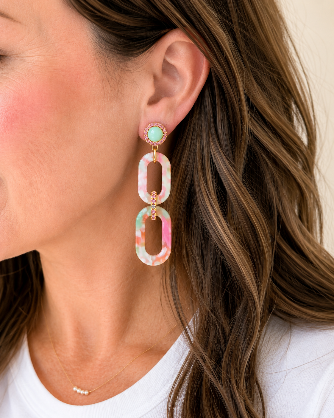 Woman wearing Hampton Drop Earrings featuring marbled acrylic links and sparkling pink rhinestone accents.