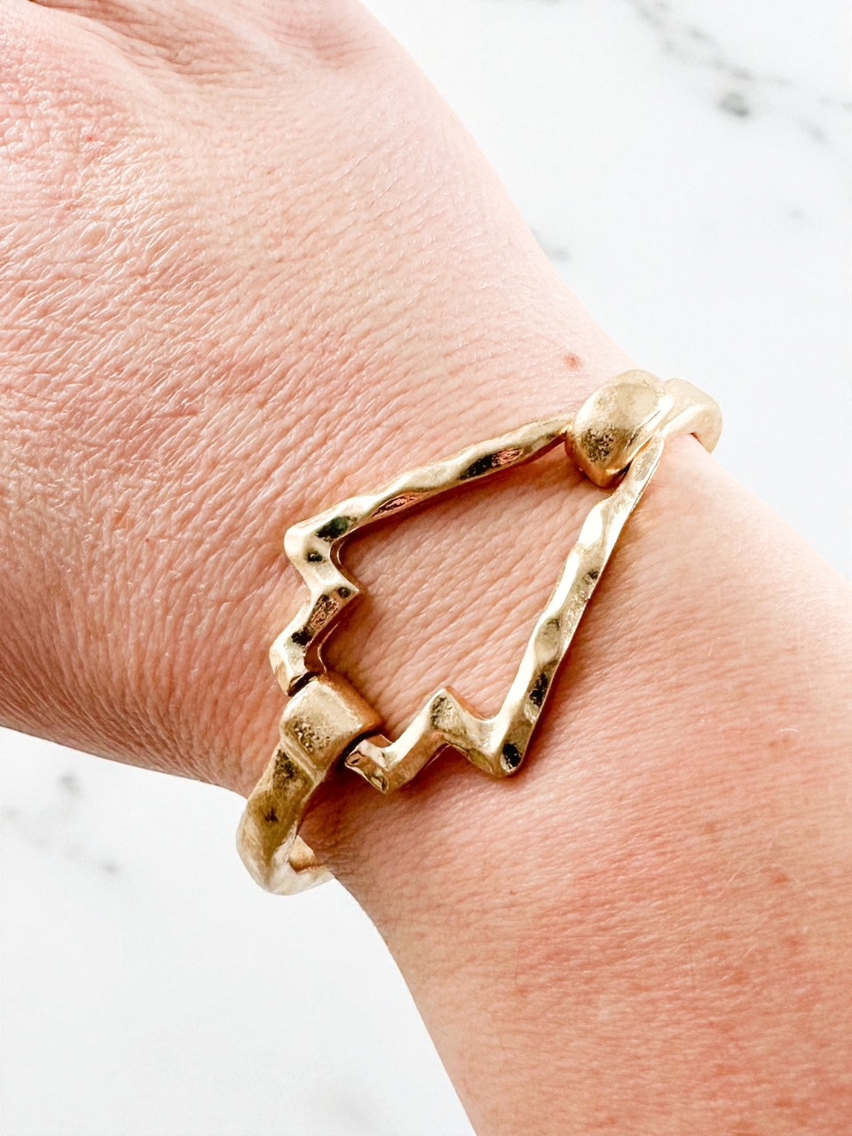 worn gold hammered arrow bracelet shown on wrist with open arrow-shaped center