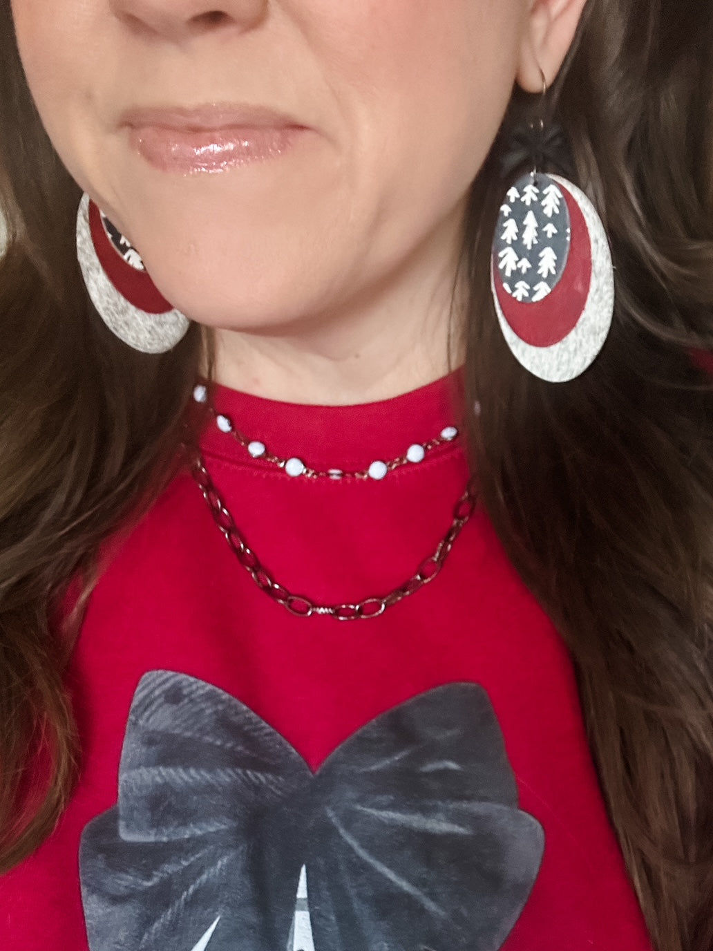 Close-up of Heirloom Pines Earrings worn with Velvet Pines Sweatshirt, showing layered leather and cork textures with bow detail.