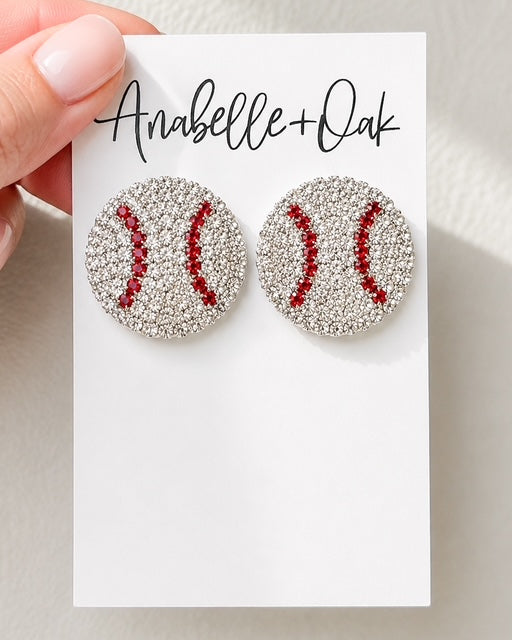 Home Run Luxe 1-inch rhinestone baseball stud earring shown in hand for size reference
